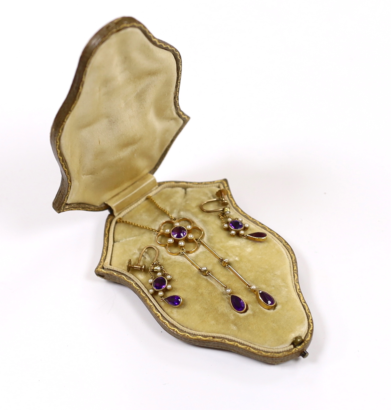 An Edwardian yellow metal, amethyst and seed pearl cluster set drop pendant necklace, 48cm and a pair if matching drop ear clips, gross weight 8.3 grams.